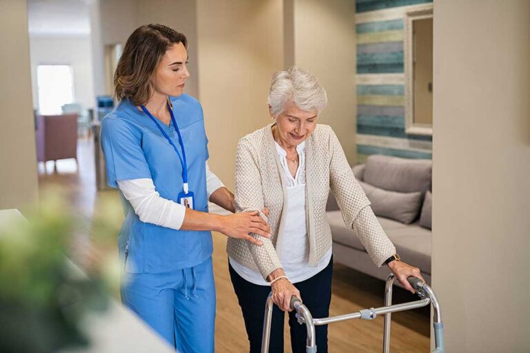 Older adult and family member look through photos together in a comfortable assisted living room.